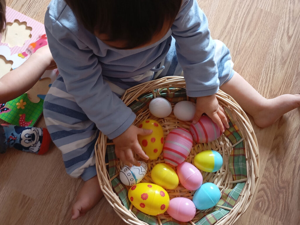 niño pequeño jugando con huevos de pascua